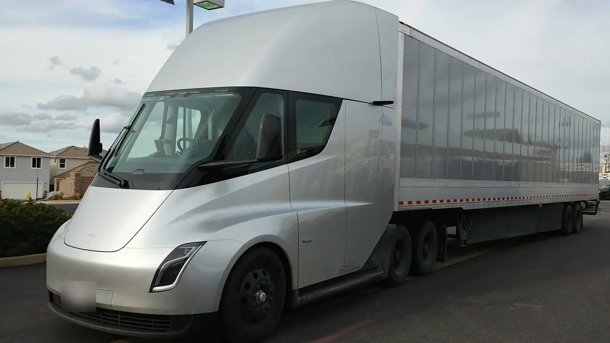 Silver Tesla Semi electric truck pulling a trailer in a parking lot